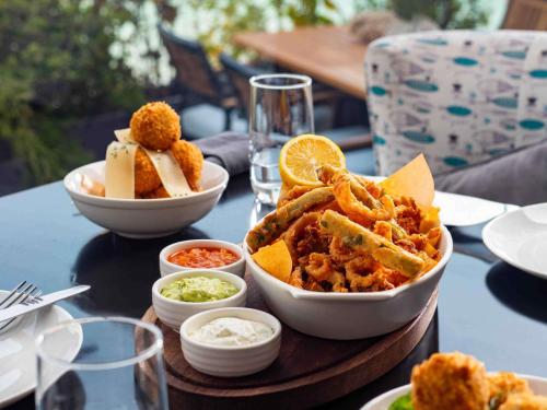 a table topped with plates of food on a table at Novotel Bahrain Al Dana Resort in Manama