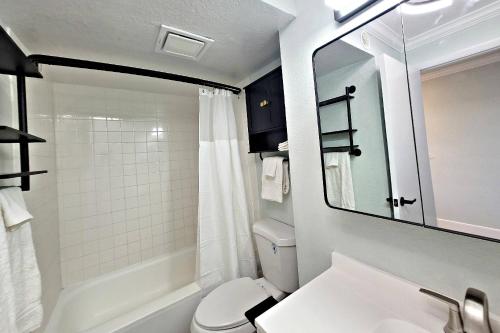 een badkamer met een wastafel, een toilet en een spiegel bij Pirates Cove Condo Unit #401 in Halifax Estates