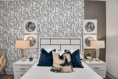 a bedroom with a bed with blue pillows and a patterned wall at Haus of Blues-HighRise-NRG Stadium-Med Center- Private Parking in Houston