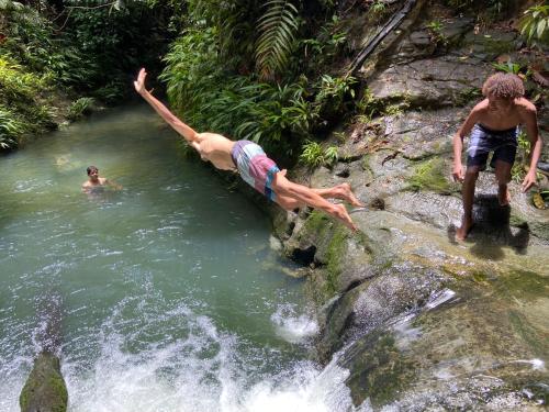 a man diving into a waterfall in a river at SURF HOUSE ESTILO LIBRE in Buenaventura