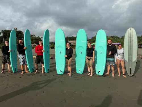 a group of people holding surfboards on the beach at SURF HOUSE ESTILO LIBRE in Buenaventura