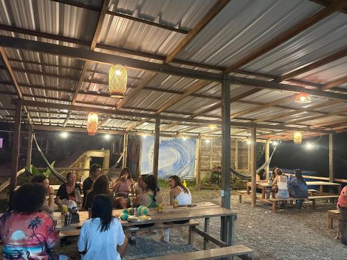 a group of people sitting at tables in a pavilion at SURF HOUSE ESTILO LIBRE in Buenaventura