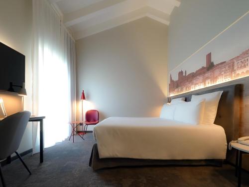 a hotel room with a bed and a tv at Mercure Bergamo Centro Palazzo Dolci in Bergamo
