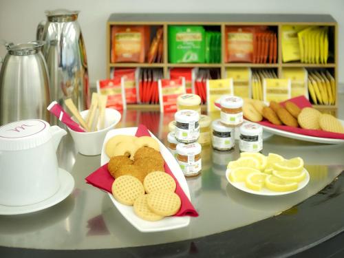 a counter with plates of food on a table at Mercure Bergamo Centro Palazzo Dolci in Bergamo