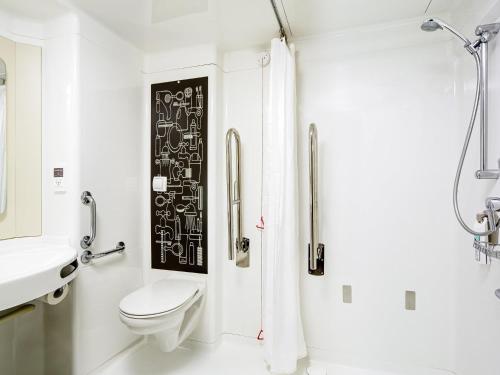 a white bathroom with a toilet and a sink at ibis London Excel-Docklands in London