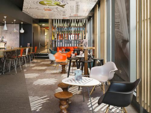 a restaurant with tables and chairs and a bar at ibis London Excel-Docklands in London