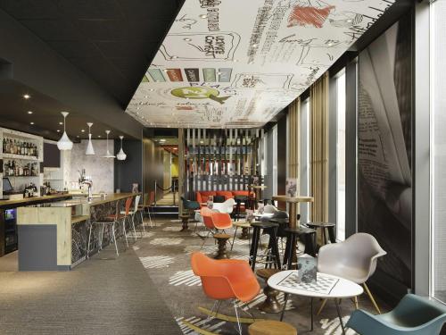 a restaurant with chairs and tables and a bar at ibis London Excel-Docklands in London