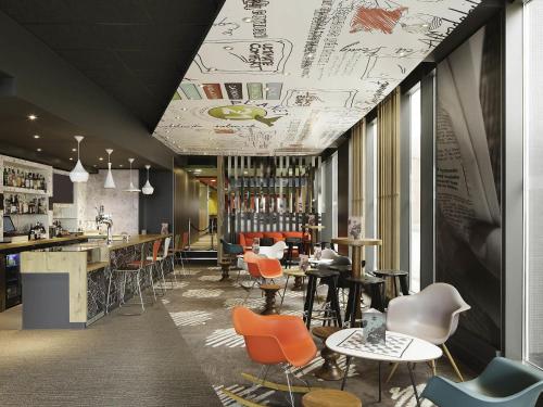 a restaurant with chairs and tables and a bar at ibis London Excel-Docklands in London
