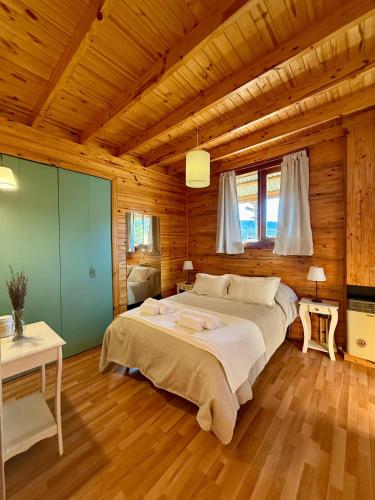 a bedroom with a large bed in a wooden room at La Casita de Arriba in San Martín de los Andes
