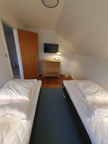a bedroom with two beds and a dresser with a tv at Lovely Holiday Home With Views Of Fields in Lebøl