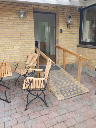 a patio with two chairs and a wooden deck at Lovely Holiday Home With Views Of Fields in Lebøl