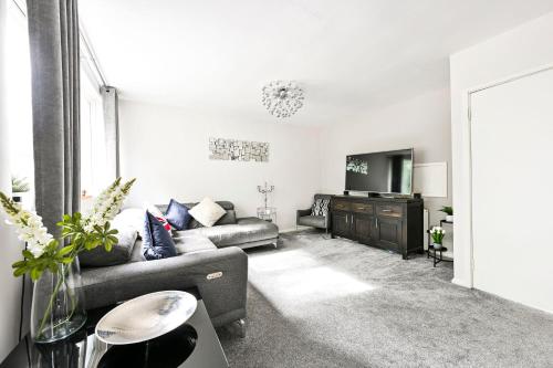 a living room with a couch and a television at Modern 3-Bed Maisonette - Epping High Street - Parking - LMV Property in Epping