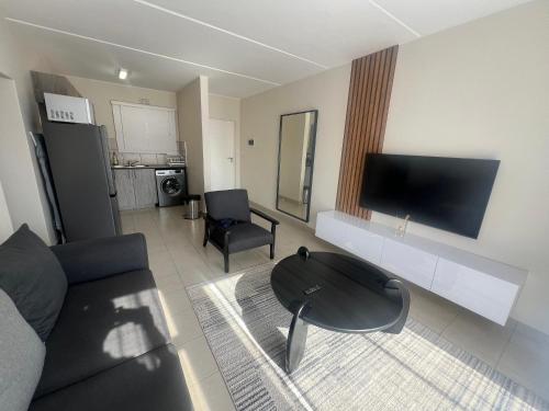 un soggiorno con un divano e un tavolo di AmeAnele Homes a Gaborone