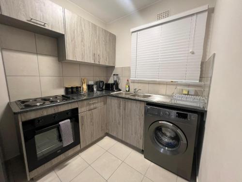 una cucina con lavatrice e lavandino di AmeAnele Homes a Gaborone