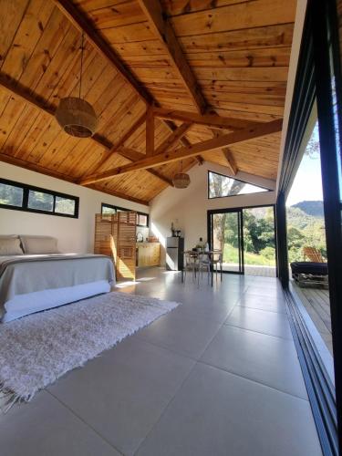 a bedroom with a bed and a wooden ceiling at Chalé Alto padrão in Brazópolis