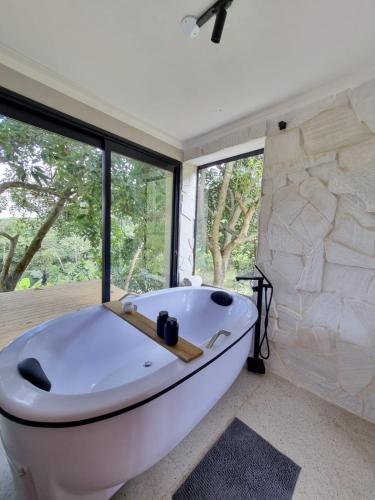 a white bath tub in a bathroom with windows at Chalé Alto padrão in Brazópolis