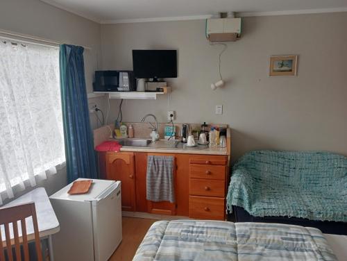 a small kitchen with a sink and a bed in a room at Applaud BnB in Drury