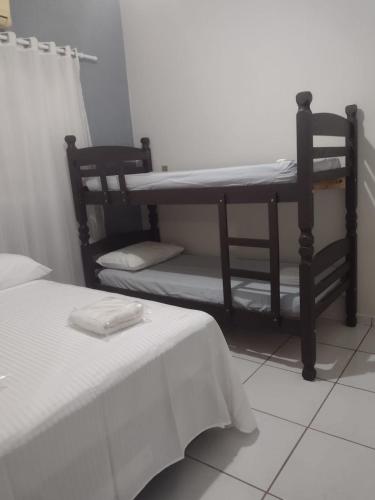 a room with two bunk beds and a table at Casa de temporada lus delicatte in Olímpia