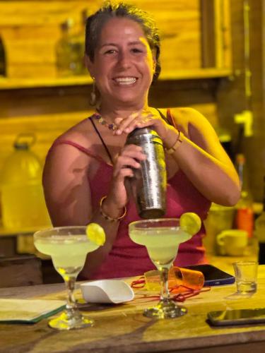 a woman standing behind a table holding a can at SURF HOUSE ESTILO LIBRE in Buenaventura