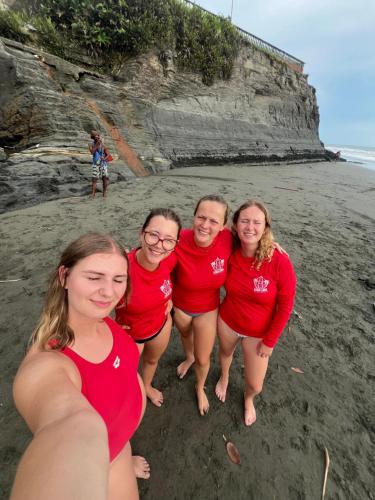 a group of people in red shirts on the beach at SURF HOUSE ESTILO LIBRE in Buenaventura