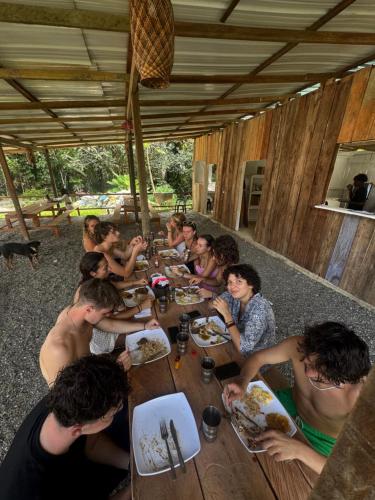 a group of people sitting at a table eating food at SURF HOUSE ESTILO LIBRE in Buenaventura