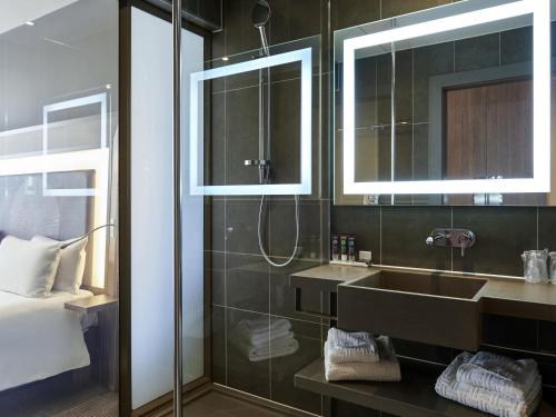 a bathroom with a sink and a shower at Novotel London Excel in London