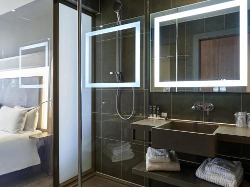 a bathroom with a sink and a shower at Novotel London Excel in London