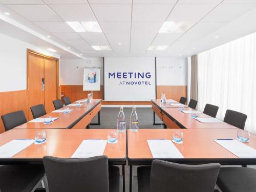 a meeting room with a long table and chairs at Novotel London Excel in London