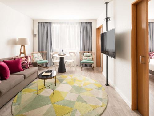 a living room with a couch and a table at Novotel Barcelona Cornellà in Cornellà de Llobregat