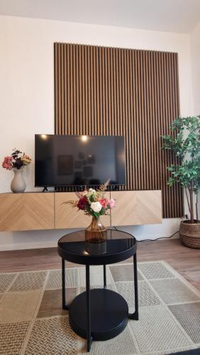 a living room with a table with flowers on it at Altstadt Apartment beim Schlossgarten in Schwerin