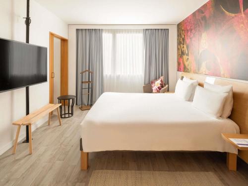 a hotel room with a large bed and a flat screen tv at Novotel Barcelona Cornellà in Cornellà de Llobregat