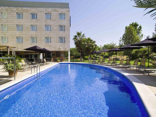 a large swimming pool in front of a building at Novotel Barcelona Cornellà in Cornellà de Llobregat