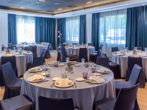 a conference room with tables and chairs and tablesktop at Novotel Barcelona Cornellà in Cornellà de Llobregat