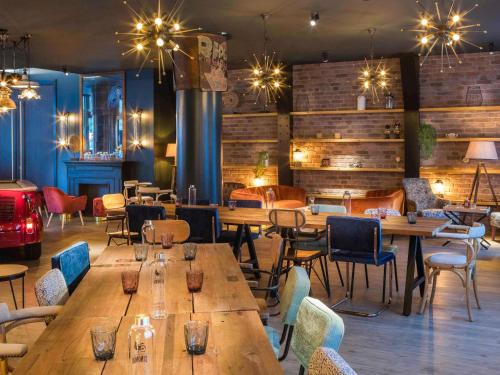 a restaurant with wooden tables and chairs at Novotel Barcelona Cornellà in Cornellà de Llobregat