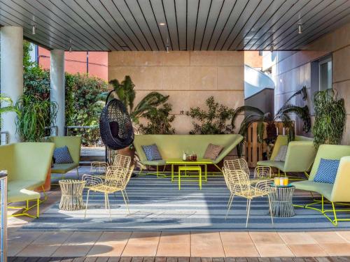 a patio with chairs and a table and chairs at Novotel Barcelona Cornellà in Cornellà de Llobregat