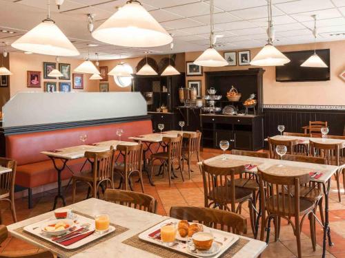 a dining room with tables and chairs and wine glasses at Ibis Murcia in Murcia