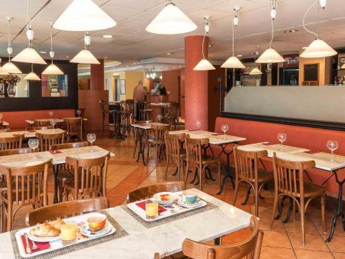a restaurant with wooden tables and chairs with food on them at Ibis Murcia in Murcia