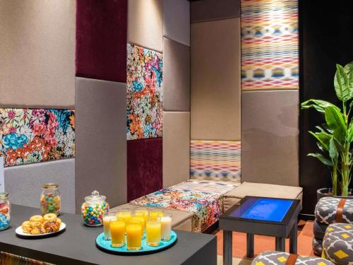 a room with a bed and glasses of orange juice at Novotel Barcelona Cornellà in Cornellà de Llobregat