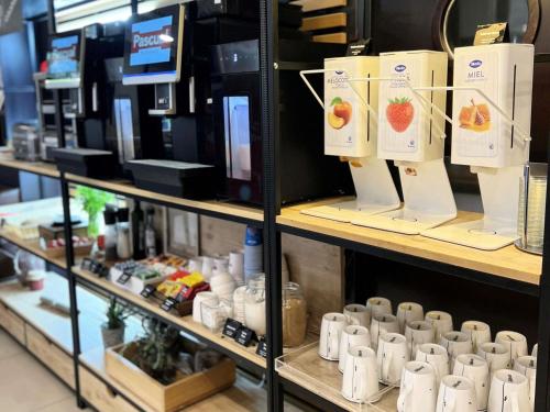 a store shelf filled with coffee cups on display at Ibis Ripollet in Ripollet