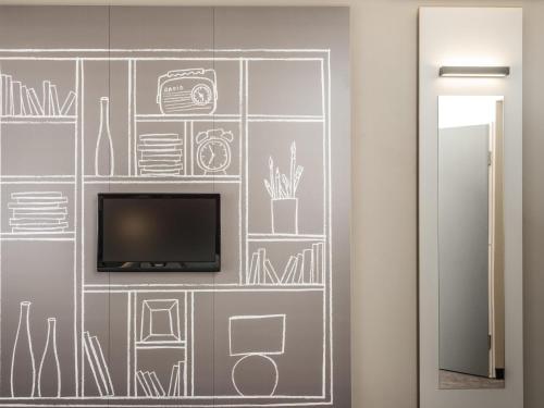 a wall mural with a tv and drawings on it at ibis Hotel Hamburg St. Pauli Messe in Hamburg