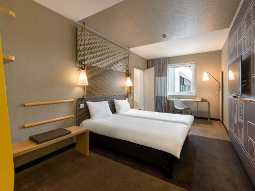 a hotel room with a large bed and a desk at ibis Hotel Hamburg St. Pauli Messe in Hamburg