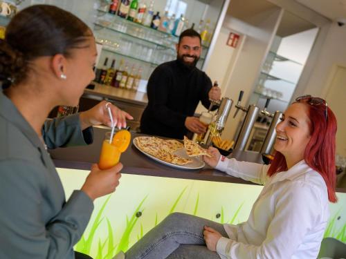 a woman sitting at a bar with a woman eating food at ibis Heilbronn City in Heilbronn
