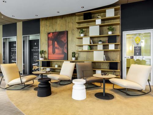 a waiting room with chairs and tables and shelves at ibis Hotel Hamburg St. Pauli Messe in Hamburg