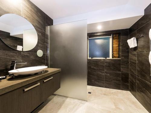 a bathroom with a sink and a mirror at Grand Mercure Puka Park Resort in Pauanui