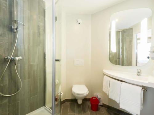 a bathroom with a shower and a toilet and a sink at Ibis Granada in Granada