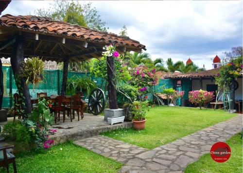 un jardín con pérgola, mesa y sillas en Gran Bonanza Hotel, en Alegría
