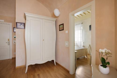 a room with a white closet and a vase of flowers at Residenza d'Epoca Relais I Miracoli in Pisa