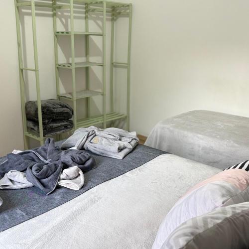 two beds with towels on the floor in a room at SEO Apê no Centro de Serra Negra -em frente a Rodoviária in Serra Negra