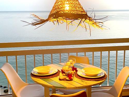 a table on a balcony with a view of the ocean at Estrela do Mar - Ocean View Apartment - Sesimbra - Falésia in Sesimbra