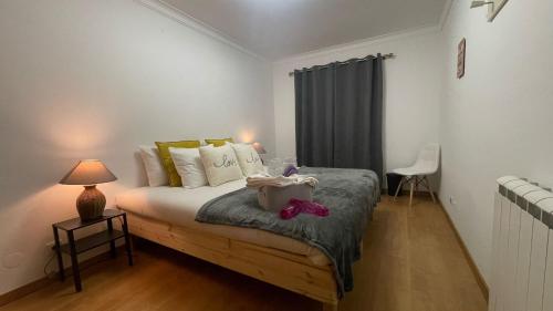 una camera da letto con un letto e un tavolo con una lampada di Apartamento com 1 quarto para casais ou amigos a 20 min de Lisboa a Montijo